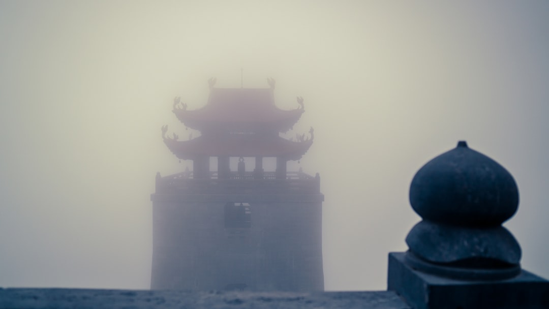 a tall tower sitting on top of a foggy hillside